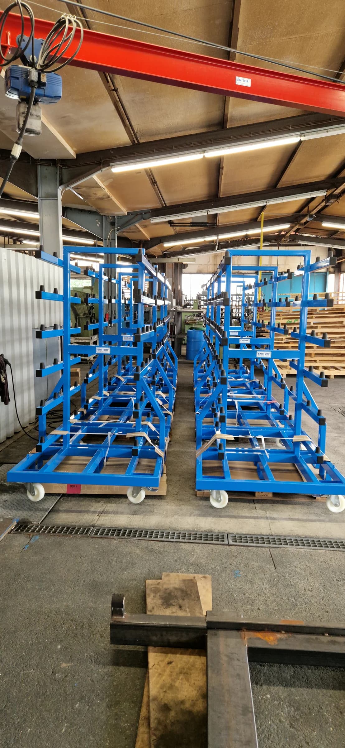 Front view of several blue painted lid racks in the ENITOR workshop