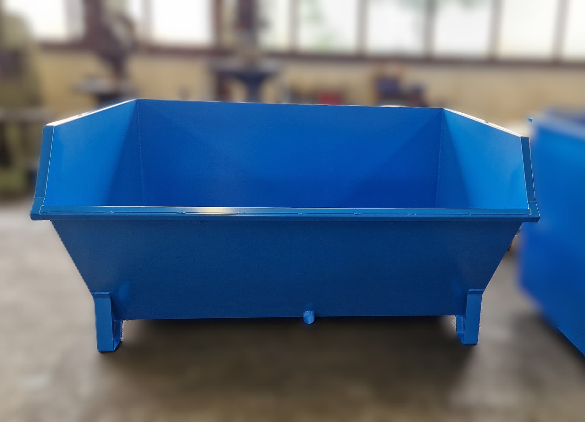 Frontansicht eines blauen Filterkuchenbehälters mit Ablaufstutzen